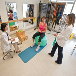 Rydia being guided by physical therapists Allison & Jenny.