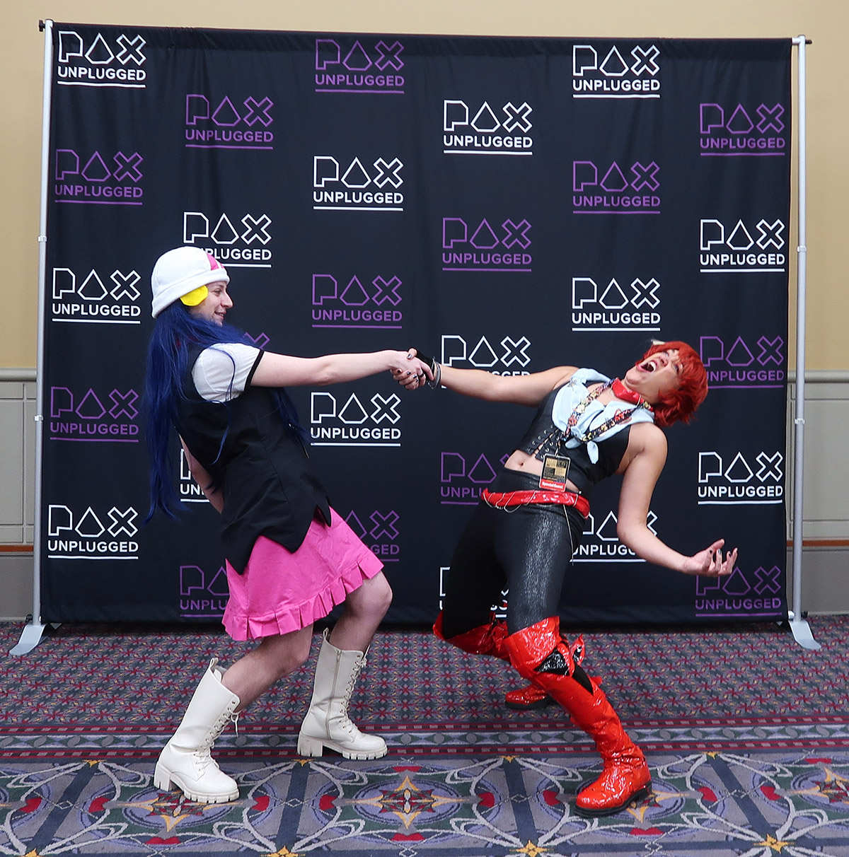 Cosplayers of
Dawn and Mela (Rydia) with purple PAX
Unplugged background
