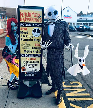 Sally & Jack with Zero in front
                              of "Meet the Pumpkin King" sign